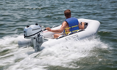 A person in a boat on the water going fast