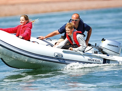 Three people in a fast boat on a lake 