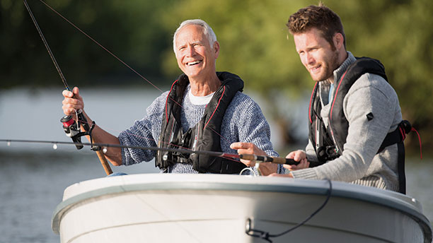 Two men fishing and smiling 